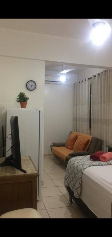 1 dormitorio con cama, sofá y reloj en Rio Vista Simple, en Río de Janeiro