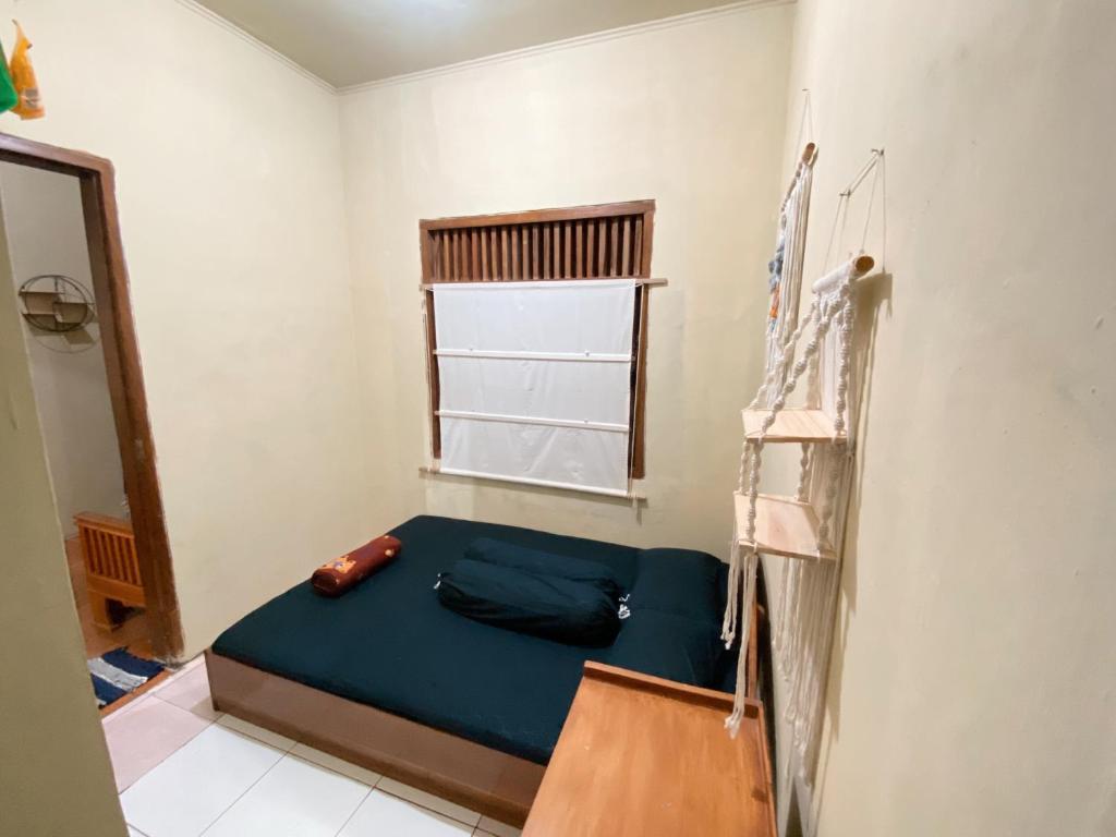 a small bedroom with a blue bed in a room at Sadewa homestay batukaras in Batukaras