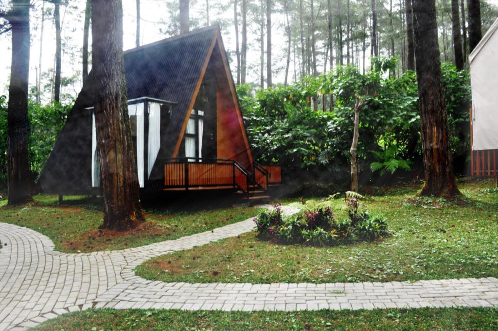 une petite cabane dans les bois avec des arbres dans l'établissement villa cikole kalaras, à Lembang