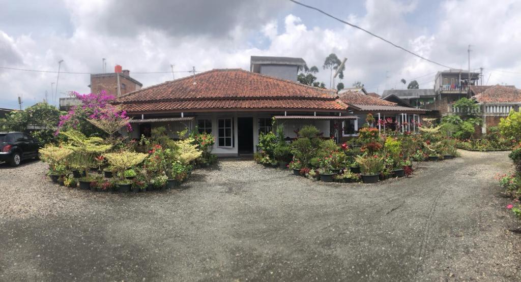 una casa con muchas flores delante de ella en Villa Situ Citiwu Ciwidey, en Ciwidey