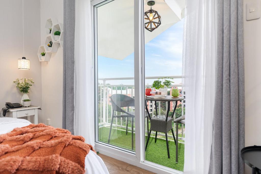 - une chambre avec un balcon doté d'une table et de chaises dans l'établissement AMANI 729, 3 Minutes to Airport, 100mbps WiFi, Free Netflix, à Pusok