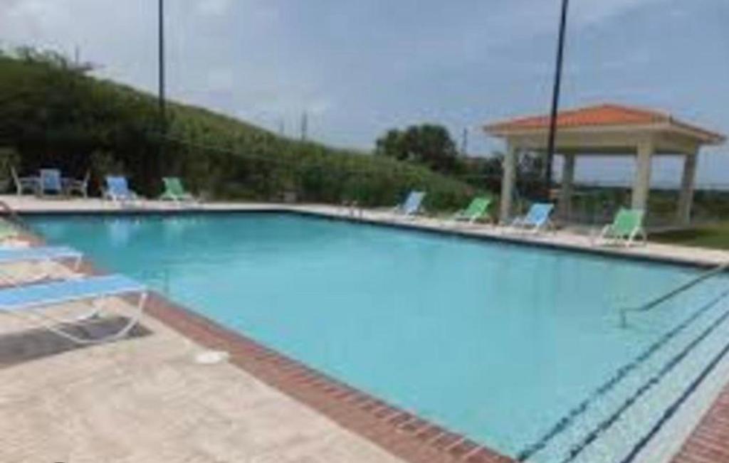 een groot blauw zwembad met stoelen en een prieel bij Hillside Village Retreat in Rio Grande