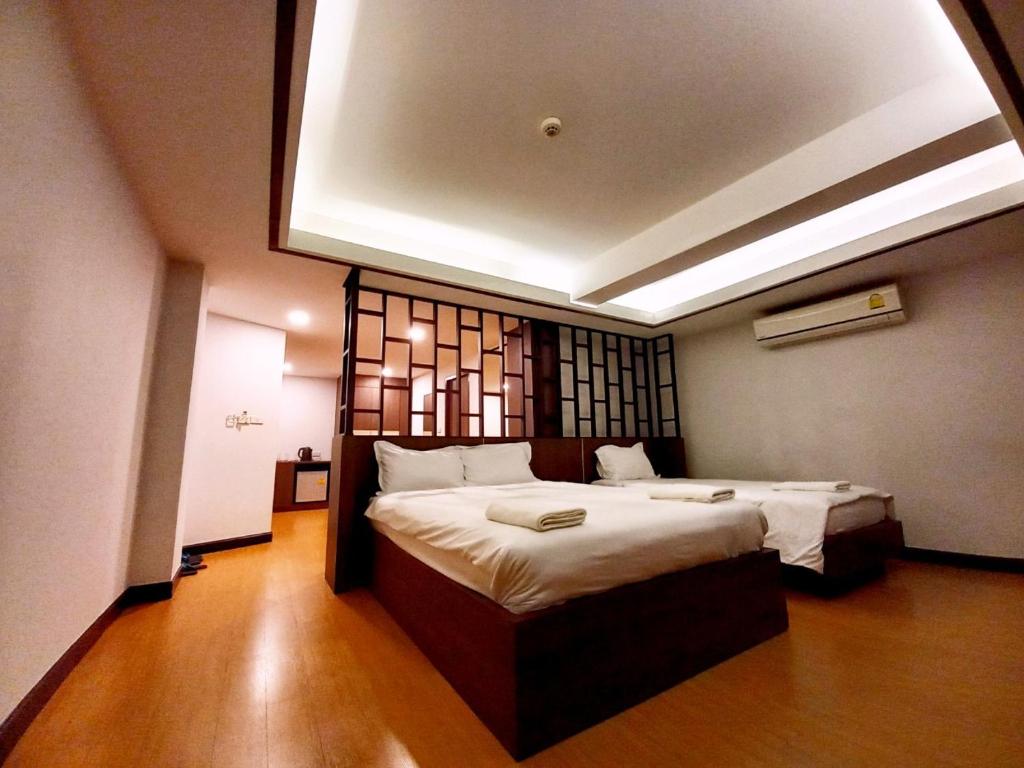 a bedroom with a large bed in a room at CHORLADA LANNA HOTEL in Chiang Mai