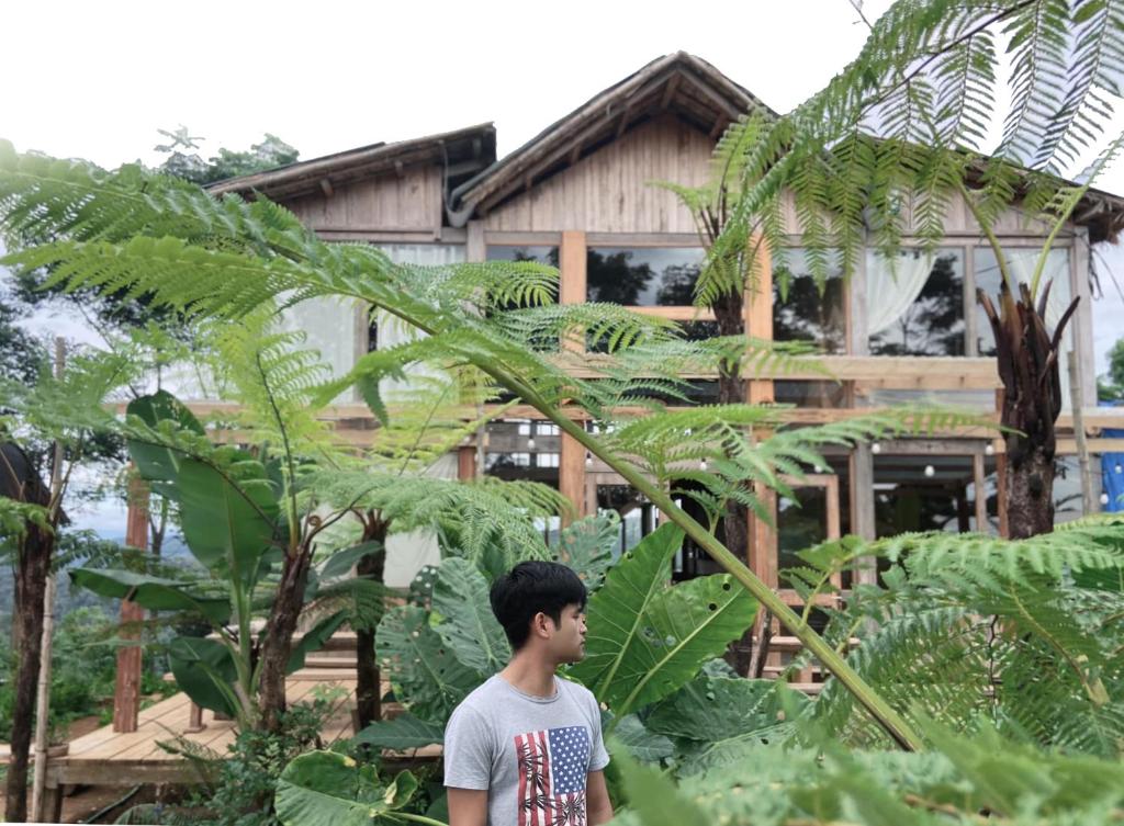 a man standing in front of a house with plants at Nẫu Ecovalley 