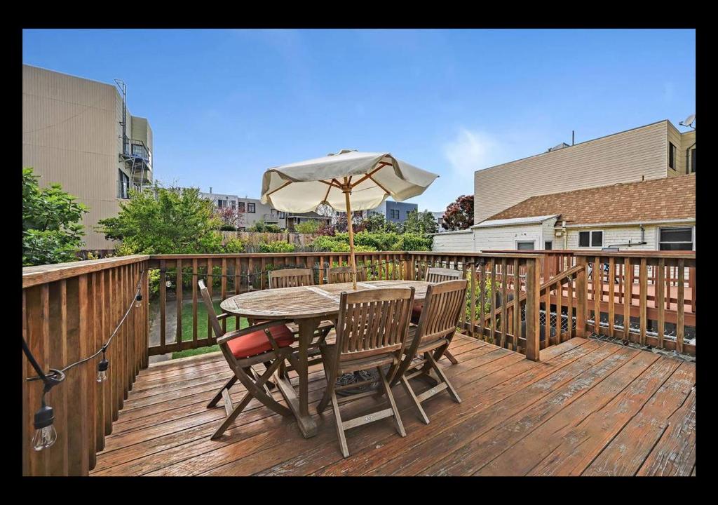 a wooden deck with a table and an umbrella at Big Lux Home w/Beaches, Golden Gate Park & Bridge. in San Francisco