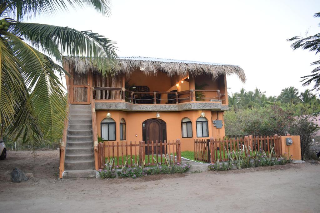 a house with a thatch roof and a staircase at Casa del Mar by Playa Larga in Agua de Correa