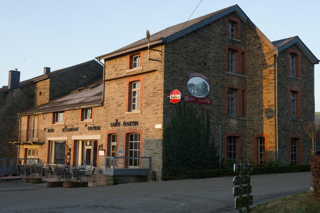 un viejo edificio de ladrillo con una señal de alto. en Auberge Saint-Martin, en Orchimont