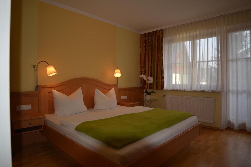 a bedroom with a large bed with a green blanket at Peterwirt in Bad Mitterndorf