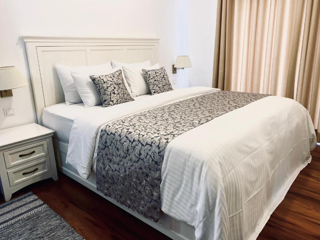 ヌワラエリヤにあるTHE WIND LILY - Lake View Luxury Apartmentの大きな白いベッドと枕のある寝室