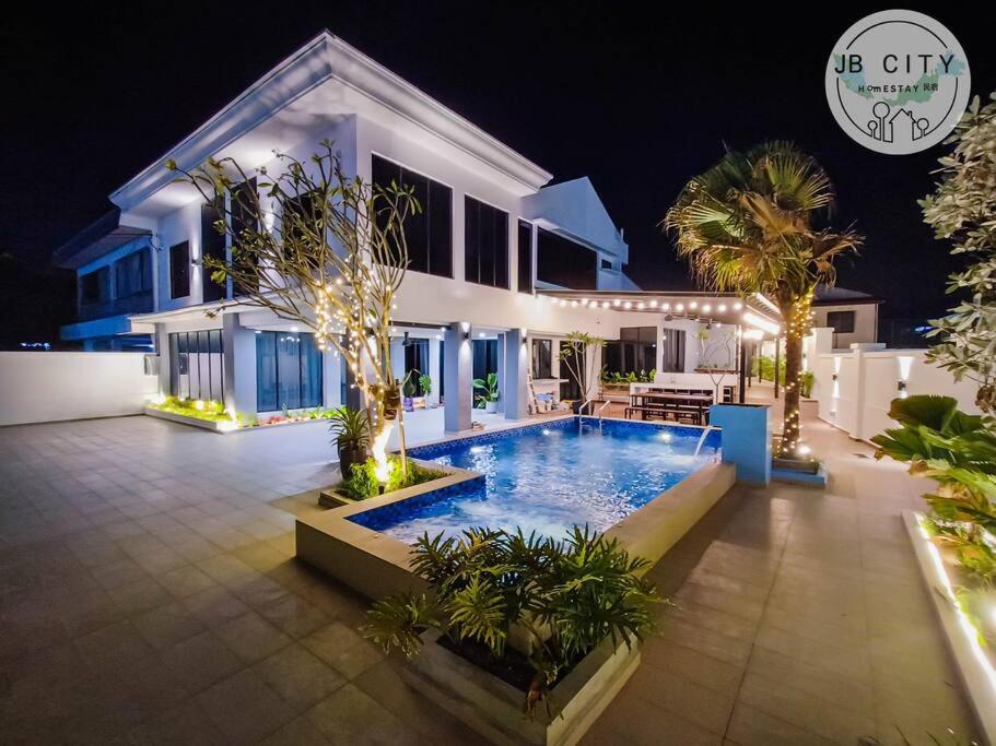 een huis met een zwembad in de nacht bij Gran Estancia Villa @ JBcity Home in Johor Bahru