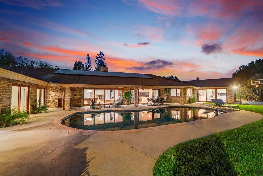 a house with a swimming pool in the yard at 5bdr park lane villa-basketball court-pool-views in Los Angeles