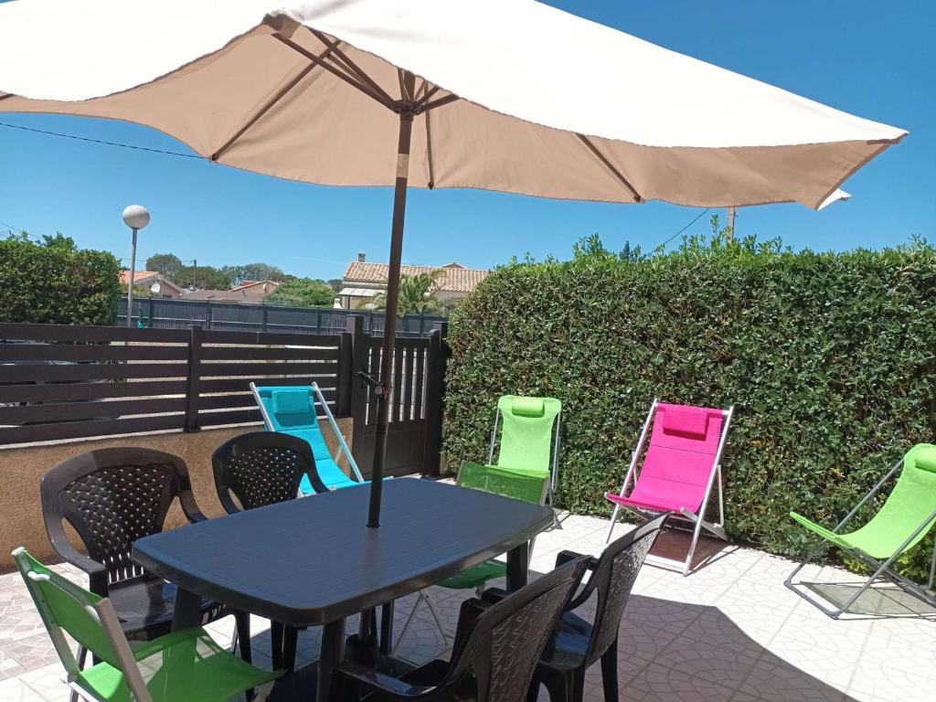 une table et des chaises avec un parasol sur une terrasse dans l'établissement Appartement T2 Cabine avec Grande Terrasse, Parking Privé, à 200m de la Plage - Valras-Plage - FR-1-701-22, à Valras-Plage