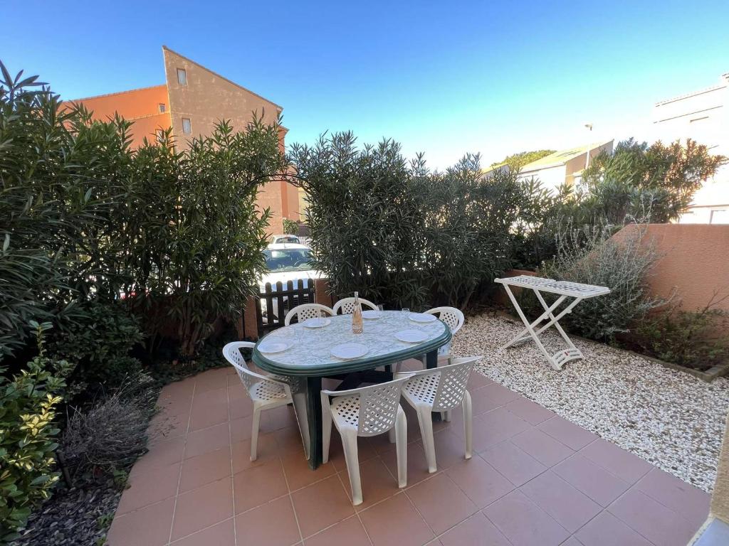 patio ze stołem i krzesłami w ogrodzie w obiekcie T3 avec Terrasse Spacieuse, Proche Plage, 4 Pers., Parking Inclus - FR-1-701-27 w mieście Valras-Plage