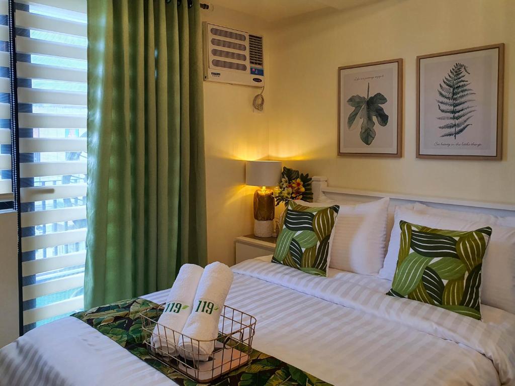1 dormitorio con 1 cama blanca y 2 almohadas en An Oasis in Tagaytay en Tagaytay