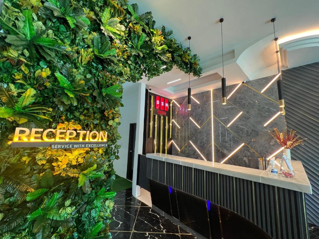a lobby with a green wall with plants at DSH Hotel in Kuantan