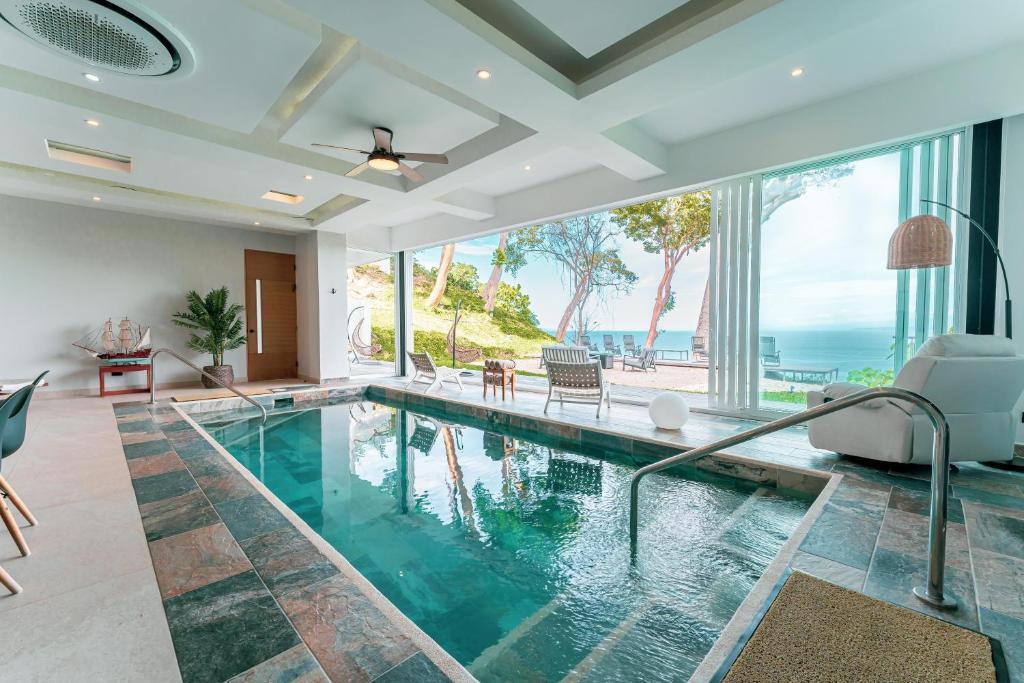 an indoor swimming pool with a view of the ocean at Childhood dream house #1 - Private Pool Ocean View in Las Mantas