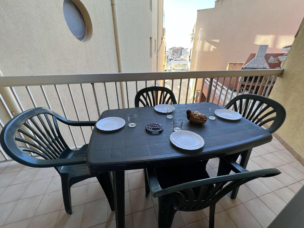 een zwarte tafel en stoelen op een balkon bij Appartement Valras-Plage, 2 pièces, 6 personnes - FR-1-701-38 in Valras-Plage