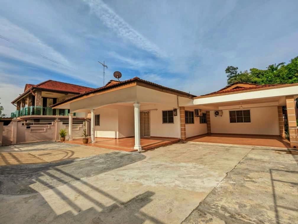 a house with a large driveway in front of it at Cozy Spacious seremban Bangalow Taman Rasah in Seremban