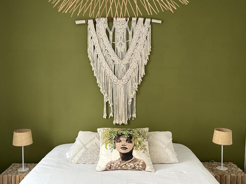 a bedroom with green walls and a bed with a headboard at Villa Couleur Nature in Salazie