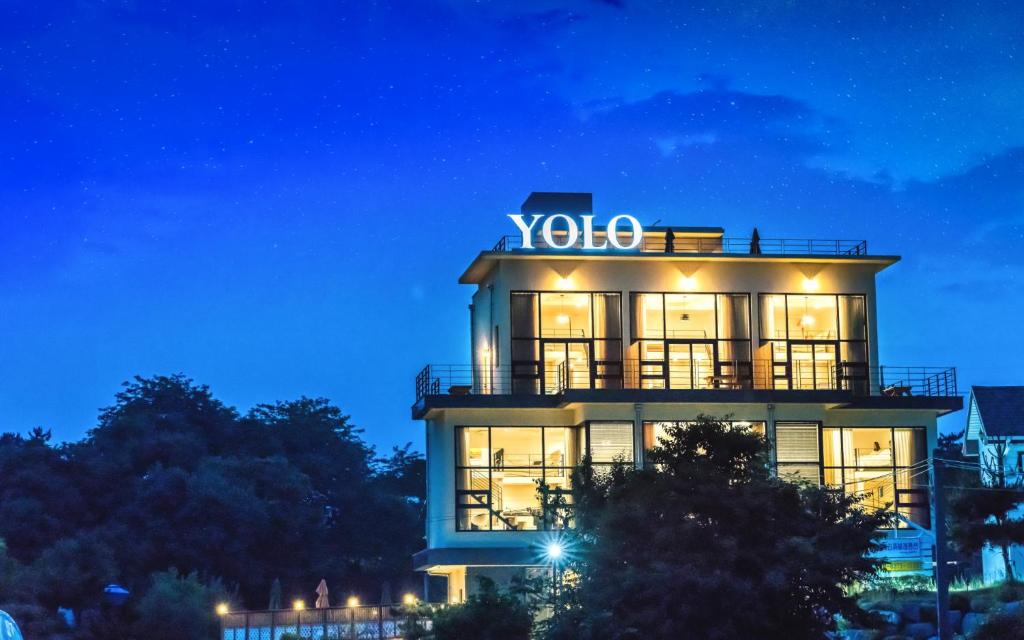 a building with a sign on top of it at night at Yolo Spa Pension in Gangneung