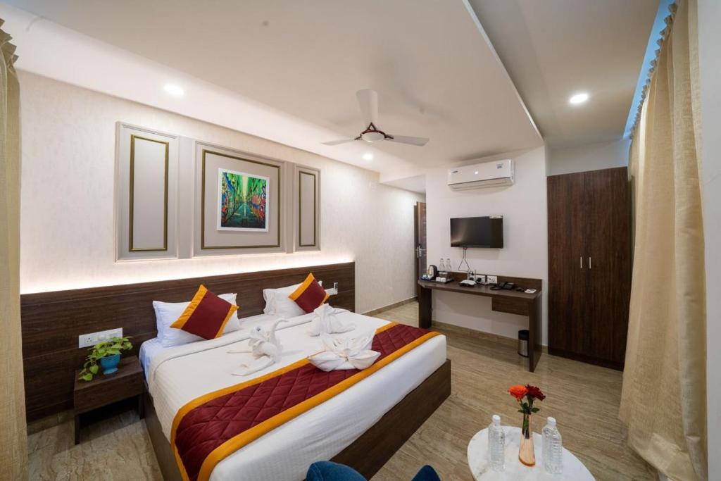 um quarto de hotel com uma cama e uma televisão em Bangalore Times em Bangalore