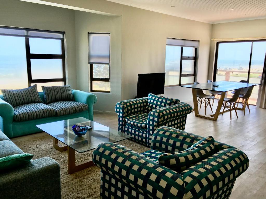 Una sala de estar con sofás y una mesa y sillas. en Ocean view, Swakopmund, 3-bedroomed apartment, en Swakopmund