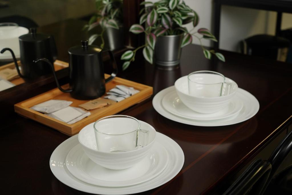 two white cups and saucers sitting on a table at Millenia Suites Cozy Studio Unit 3003 in Manila