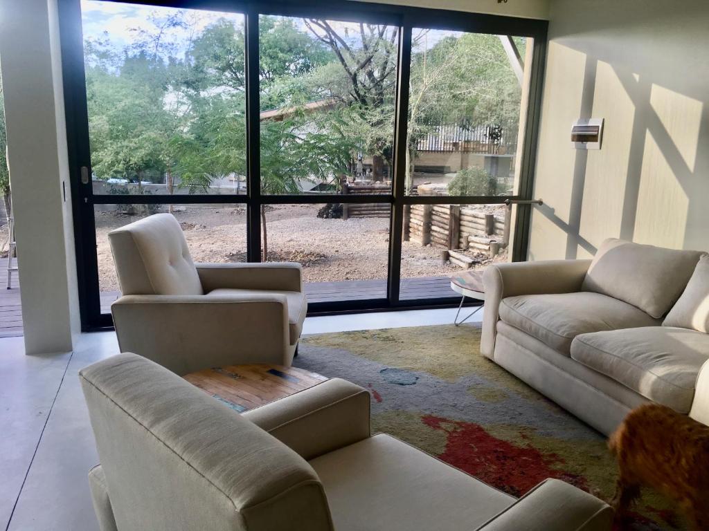 a living room with two couches and a large window at Klein Windhoek Garden flat in Windhoek