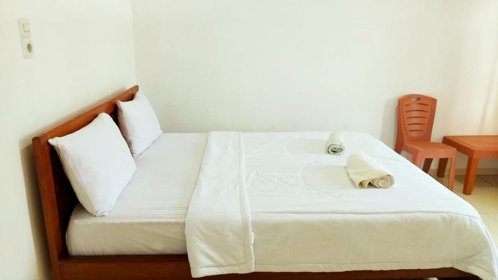 um quarto com uma cama com lençóis brancos e almofadas em Filomena Lodge em Ende