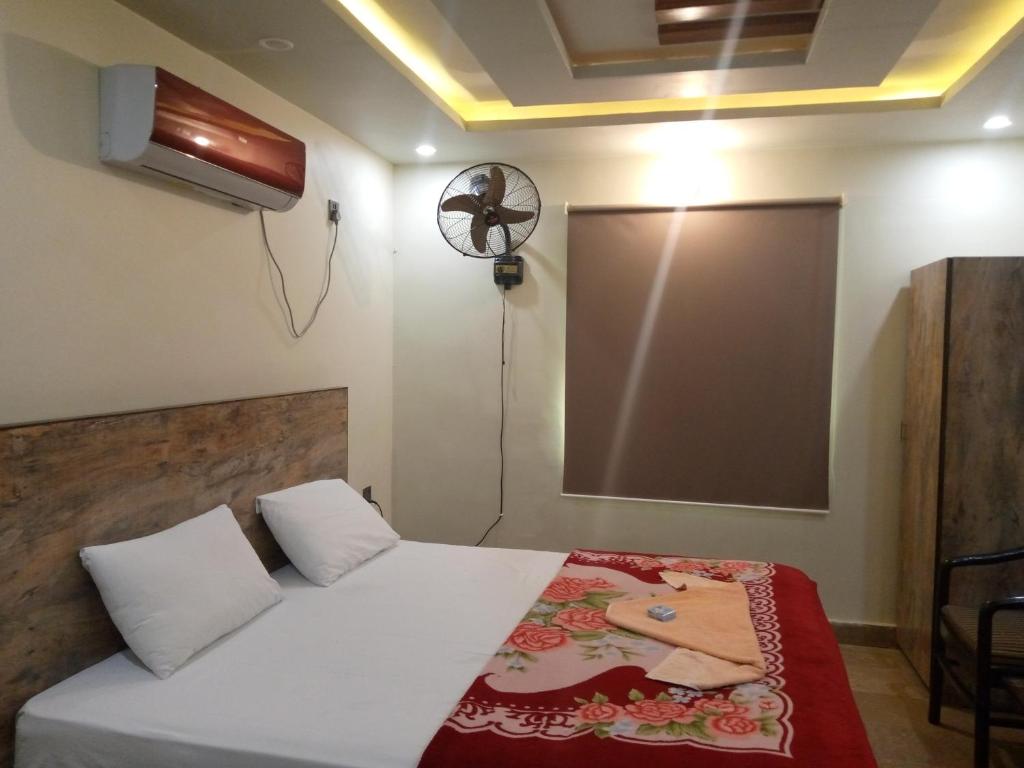- une chambre avec un lit et un écran de projection dans l'établissement Pearl Cottage Airport, à Karachi
