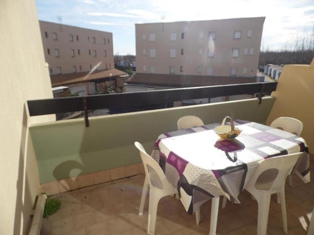 une table et des chaises sur un balcon avec vue dans l'établissement Appartement 2 pièces avec mezzanine et parking privé, animaux admis - FR-1-326-405, à Marseillan