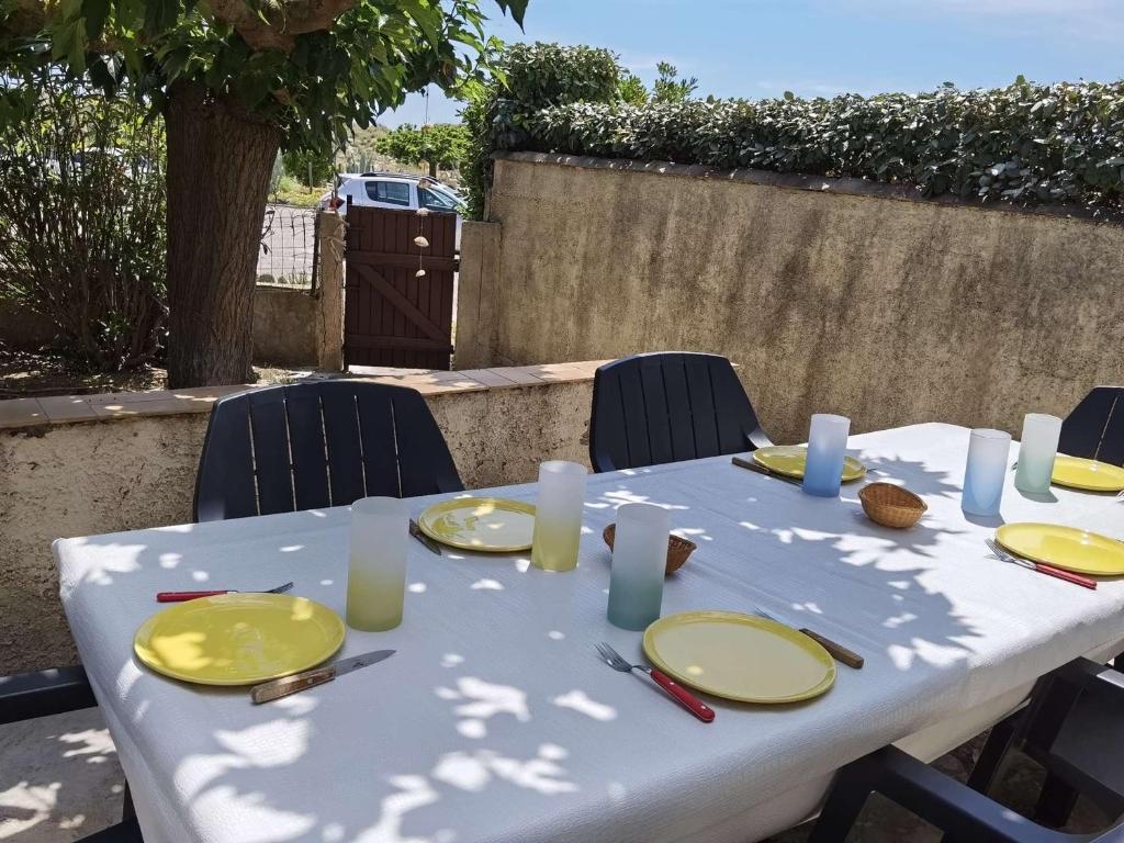d'une table blanche avec des plaques jaunes et des bougies. dans l'établissement Maison spacieuse climatisée, 3 chambres, terrasse, cuisine neuve, accès direct à la mer, à Marseillan - FR-1-326-719, à Marseillan