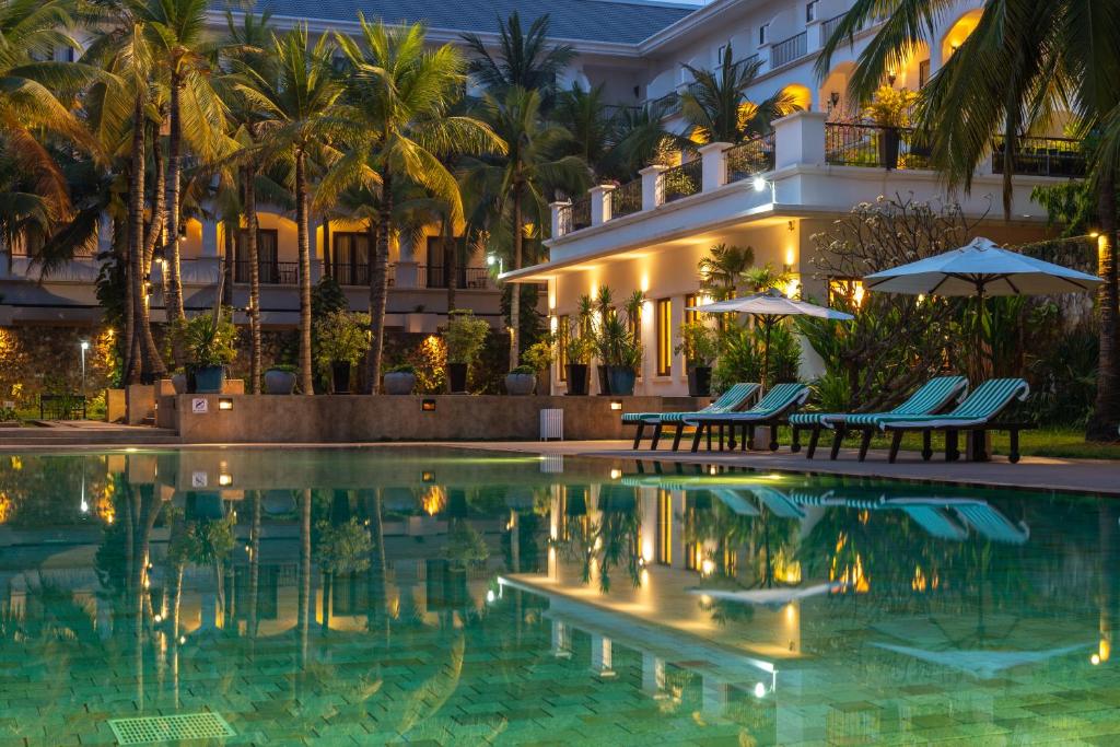 a hotel with a swimming pool in front of a building at Lotus Blanc Resort in Siem Reap