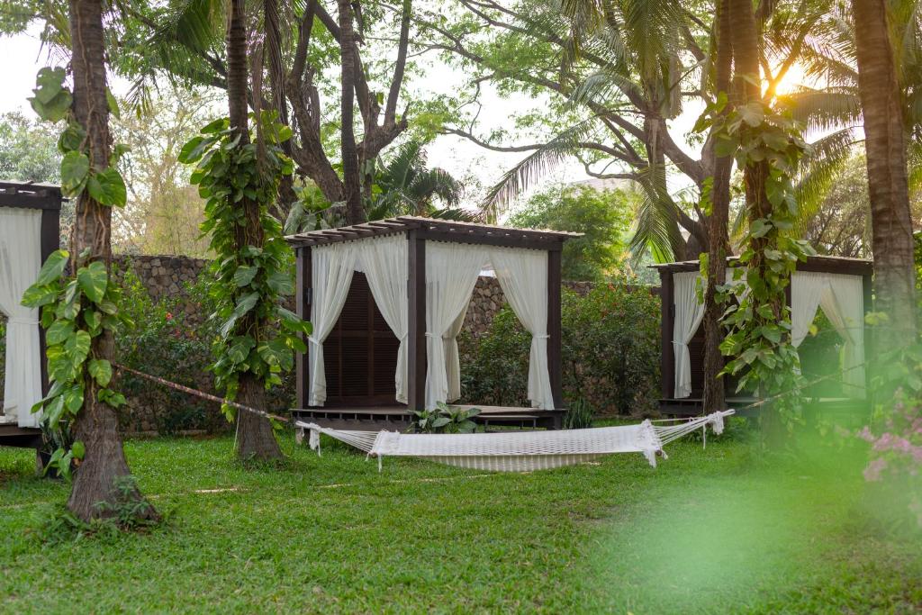 a hammock in the middle of a yard with trees at Lotus Blanc Resort in Siem Reap