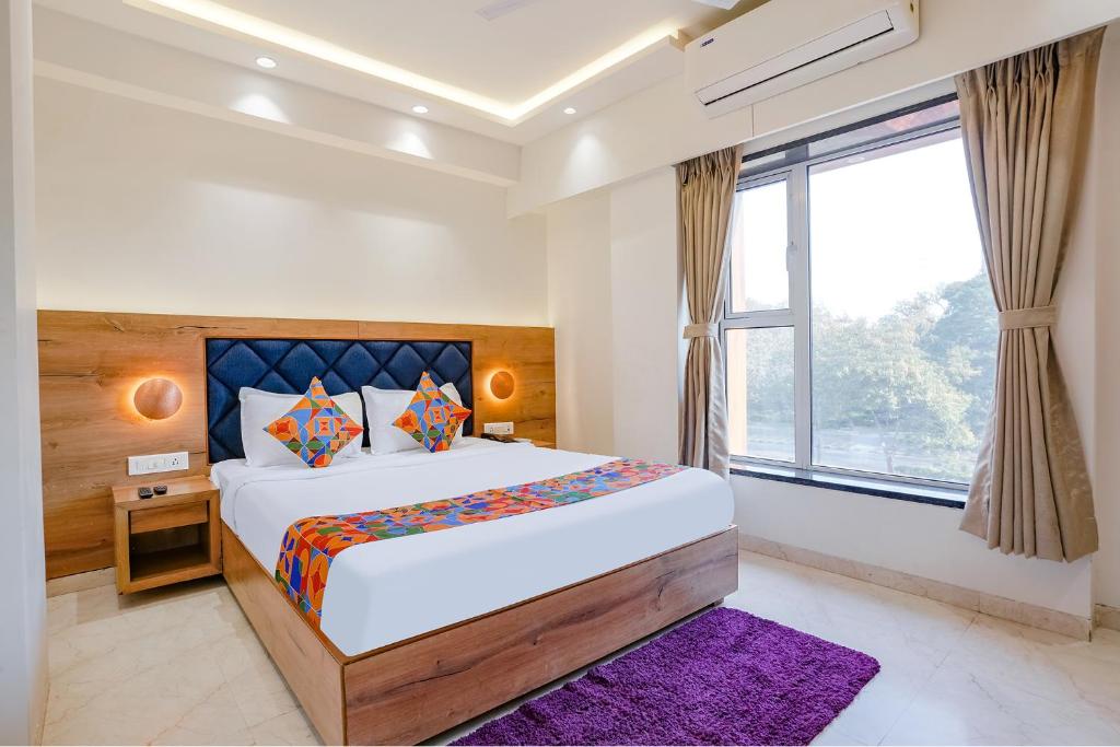 a bedroom with a large bed and a window at FabHotel Pancharatna Regency in Pune