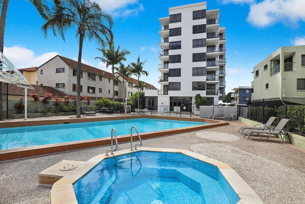 a swimming pool in front of a apartment building at Aqualine Apartments On The Broadwater in Gold Coast