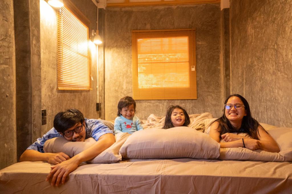 un groupe de personnes dormant sur un lit dans l'établissement Tararom ธาราลม, 