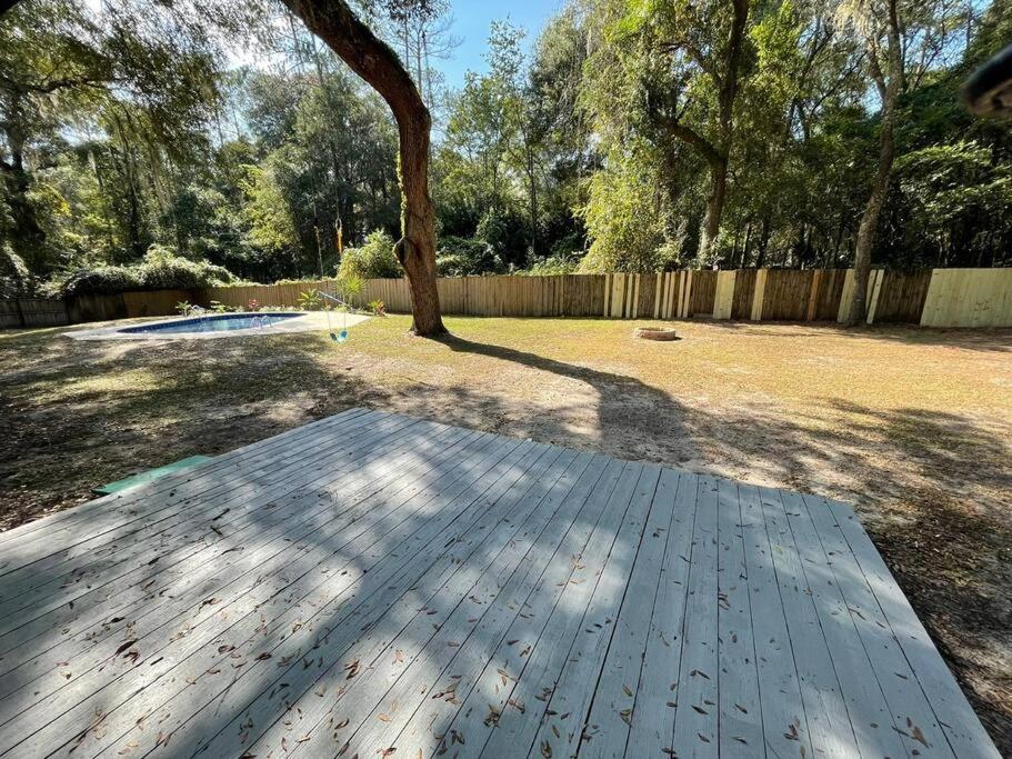 una terrazza in legno in un cortile con un albero di Spacious Gainesville Getaway with Pool and large private yard a West Hills
