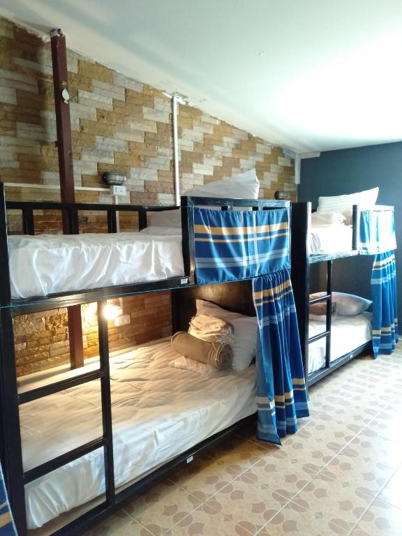 una habitación con tres literas en una habitación en BedCabin, en Chiang Rai