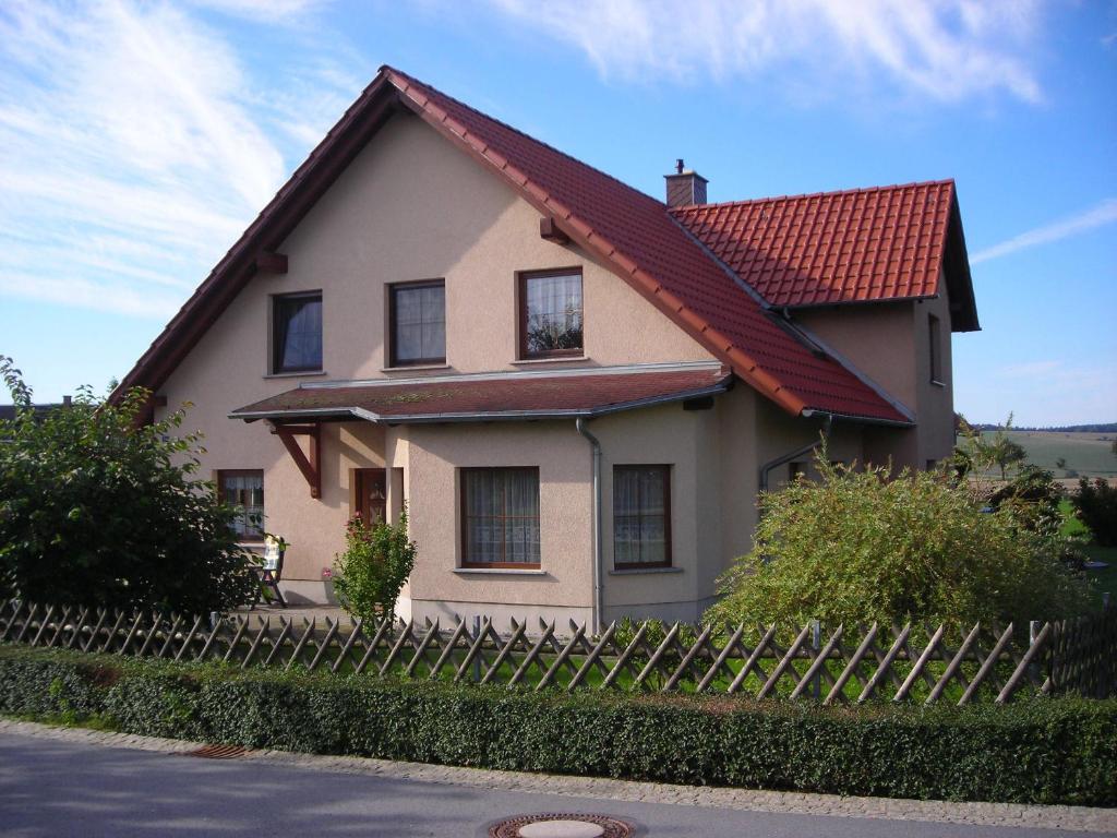 シュトルペンにあるFerienwohnung Gisela Kästner Stolpenの赤い屋根と柵のある家