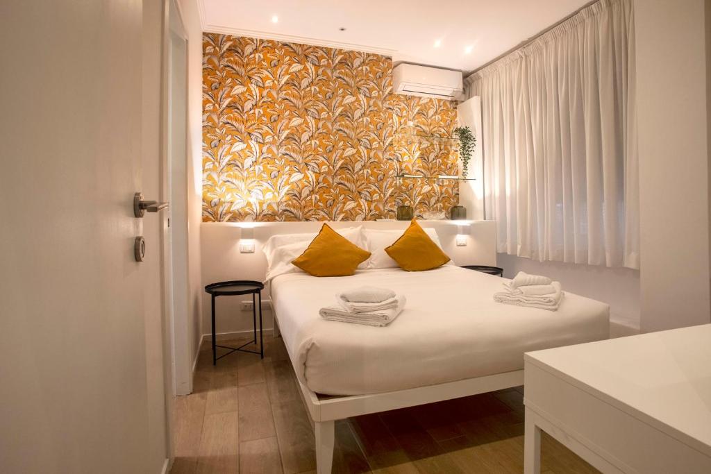 a bedroom with a white bed with yellow pillows at IV House in Rome
