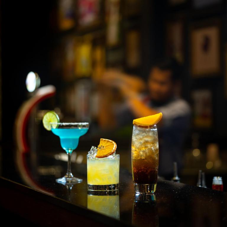 two cocktails sitting on a table in a bar at Lotus Blanc Resort in Siem Reap