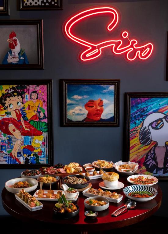 a table full of food and a neon sign at Lotus Blanc Resort in Siem Reap