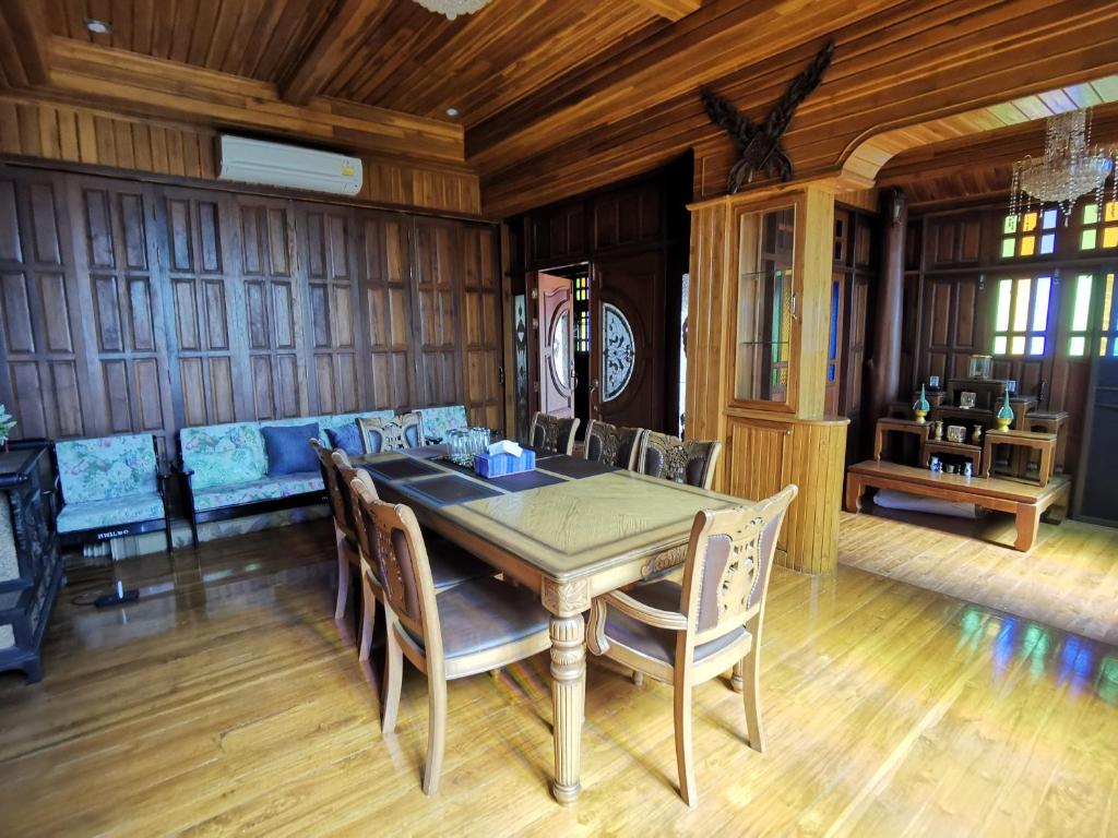 a dining room with a table and chairs at Thai traditional wooden house in Ban Nong Bu