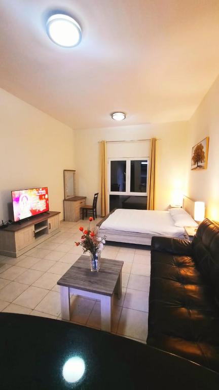 sala de estar con cama, sofá y TV en Stufio flat DG085, Close to The Gardens Metro 6 min walkable, en Dubái