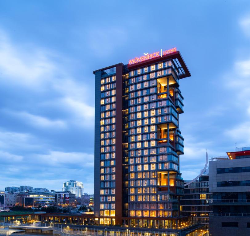 ein hohes Gebäude mit einem Schild darüber in der Unterkunft Movenpick Living Istanbul West in Istanbul