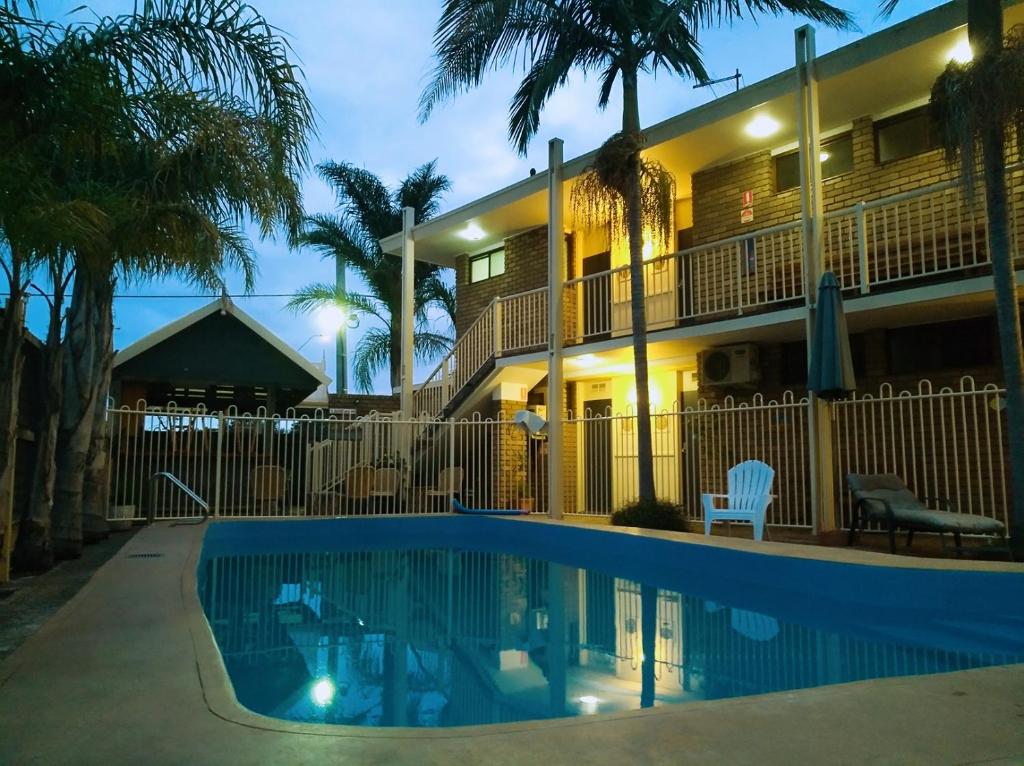a hotel with a swimming pool in front of a building at Abel Tasman Waterfront Motel in Lakes Entrance