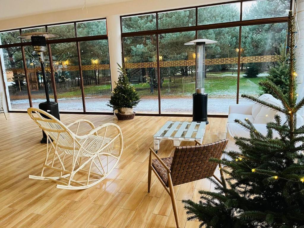 una sala de estar con un árbol de Navidad y sillas en Miodowy Zakątek Całoroczne domki i pokoje przy Suntago, Deepspot, en Mszczonów