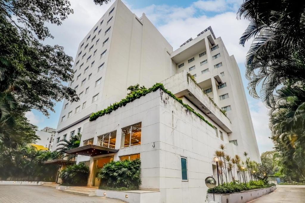 a large white building with plants on it at Lemon Tree Hotel Electronics City in Bangalore