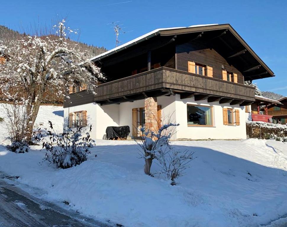 a house with a snow covered yard in front at Bergsonne in Reit im Winkl